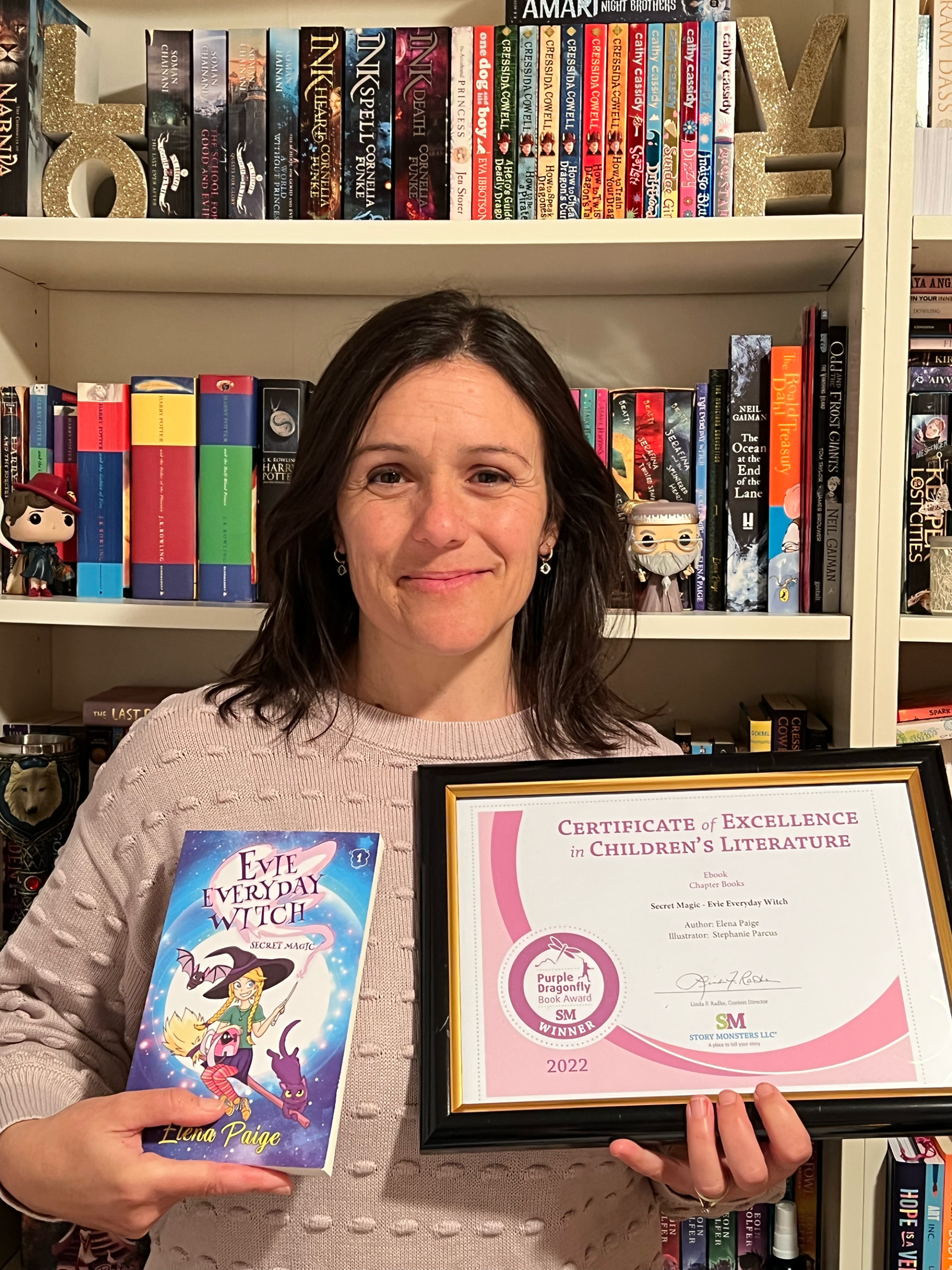 Elena Paige holding her Secret Magic Award for children's writing
